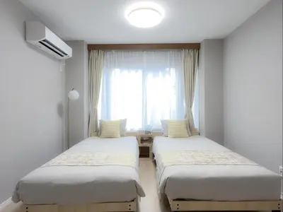 two beds in a room with a window at Mando Hotel \u6b65\u884c\u81f3 Asakusa Ueno in Tokyo