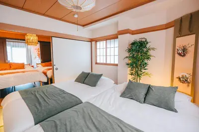 a bedroom with two beds and a potted plant at Otter Stay - Ikebukuro in Tokyo