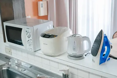 a kitchen counter with a microwave and appliances on it at Otter Stay - Ikebukuro in Tokyo