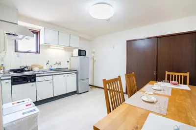 a kitchen with a wooden table and a dining room at Room 303, a 6-minute walk from Tokyo Koiwa Station Direct connected to Shinjuku and Akihabara Stations Comfortable one-bedroom apartment with separate wet and dry areas in Tokyo