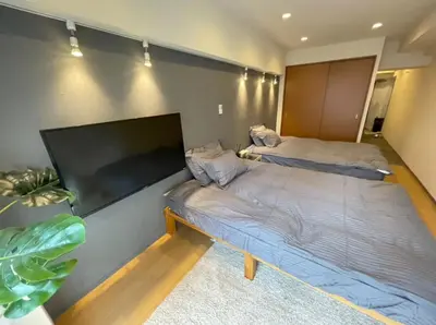 two beds in a room with a large flat screen tv at yuki shinjuku okubo 5F 502-SJ0044 in Tokyo