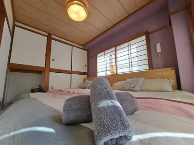 a bedroom with two beds and two windows at \u7a7a\u6e2f\u304b\u3089\u76f4\u901a\u306e\u548c\u30e2\u30c0\u30f3\u306a\u30b9\u30ab\u30a4\u30c4\u30ea\u30fc\u30a2\u30d1\u30fc\u30c8\u30e1\u30f3\u30c8 \u58a8\u706f\u5eb5-Bokuto-an- in Tokyo