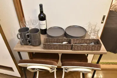 a table with a bottle of wine and glasses at \u7a7a\u6e2f\u304b\u3089\u76f4\u901a\u306e\u548c\u30e2\u30c0\u30f3\u306a\u30b9\u30ab\u30a4\u30c4\u30ea\u30fc\u30a2\u30d1\u30fc\u30c8\u30e1\u30f3\u30c8 \u58a8\u706f\u5eb5-Bokuto-an- in Tokyo