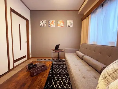 a living room with a couch and a table at \u7a7a\u6e2f\u304b\u3089\u76f4\u901a\u306e\u548c\u30e2\u30c0\u30f3\u306a\u30b9\u30ab\u30a4\u30c4\u30ea\u30fc\u30a2\u30d1\u30fc\u30c8\u30e1\u30f3\u30c8 \u58a8\u706f\u5eb5-Bokuto-an- in Tokyo