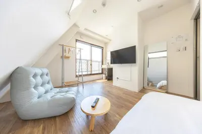 a living room with a white bed and a chair at The best Nakano house 4 minutes to station in Tokyo