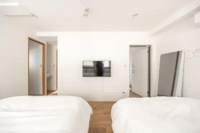 two beds in a room with white walls at The best Nakano house 4 minutes to station in Tokyo