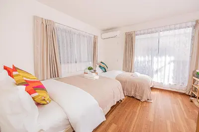 a bedroom with two beds and a large window at \u8cb8\u5207\u4e00\u8ed2\u5bb6 5ldk \u4eac\u6210\u66f3\u821f\u99c5\u304b\u3089\u5f92\u6b6910\u5206 \u6700\u592710\u540d \u5bb6\u65cf \u30b0\u30eb\u30fc\u30d7\u65c5\u884c\u306b\u6700\u9069 100\u5e73 in Tokyo