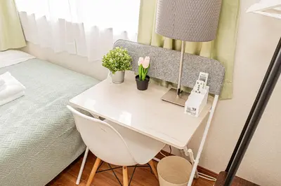 a desk with flowers and a lamp in a bedroom at \u8cb8\u5207\u4e00\u8ed2\u5bb6 5ldk \u4eac\u6210\u66f3\u821f\u99c5\u304b\u3089\u5f92\u6b6910\u5206 \u6700\u592710\u540d \u5bb6\u65cf \u30b0\u30eb\u30fc\u30d7\u65c5\u884c\u306b\u6700\u9069 100\u5e73 in Tokyo