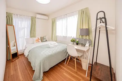 a bedroom with a bed and a desk and a table at \u8cb8\u5207\u4e00\u8ed2\u5bb6 5ldk \u4eac\u6210\u66f3\u821f\u99c5\u304b\u3089\u5f92\u6b6910\u5206 \u6700\u592710\u540d \u5bb6\u65cf \u30b0\u30eb\u30fc\u30d7\u65c5\u884c\u306b\u6700\u9069 100\u5e73 in Tokyo