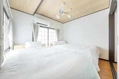 a bedroom with a large white bed and a window at A unique cozy townhouse perfect for up to 5 guests in Tokyo