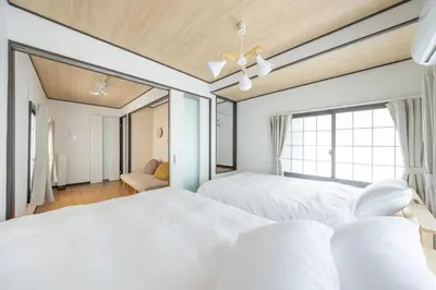 two beds in a bedroom with a window at A unique cozy townhouse perfect for up to 5 guests in Tokyo
