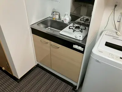 a small kitchen with a sink and a stove at Zenith Shinjuku Hinoki Building A by Tranova in Tokyo