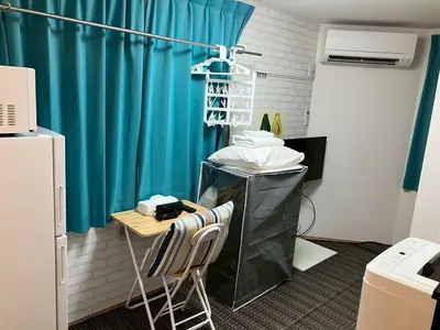 a room with a table and a blue curtain at Zenith Shinjuku Hinoki Building A by Tranova in Tokyo