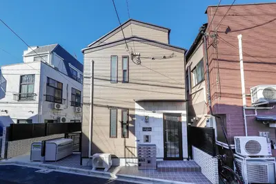 a building on a street next to two buildings at Zenith Shinjuku Hinoki Building A by Tranova in Tokyo