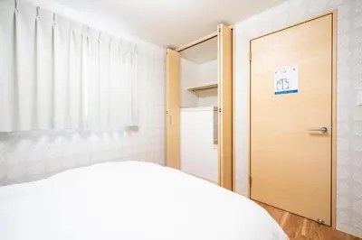 a bedroom with a bed and a wooden door at Familia Kamata 2 in Tokyo