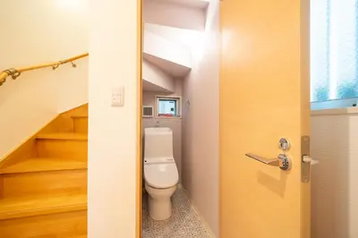 a bathroom with a toilet and a staircase at Familia Kamata 2 in Tokyo