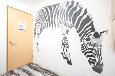 a zebra mural on a wall next to a door at Familia Kamata 2 in Tokyo