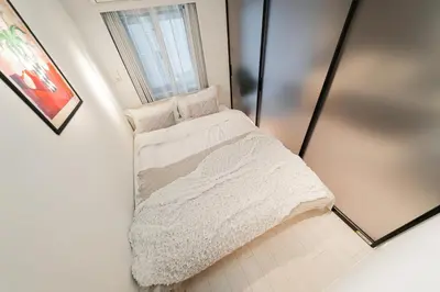 a small bedroom with a bed in a mirror at Brand New Apt near Roppongi 4min Walk in Tokyo