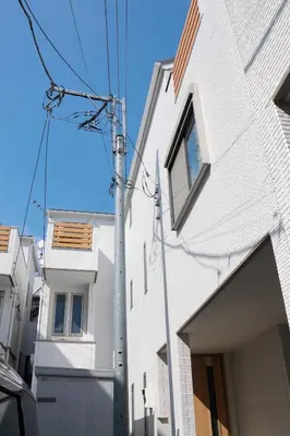 a white building with a pole next to it at SunRise STAY Haruna in Tokyo
