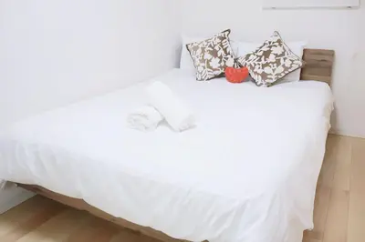 a white bed with pillows on top of it at SunRise STAY Haruna in Tokyo