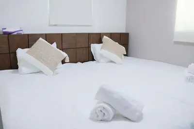 a white bed with white sheets and pillows at SunRise STAY Haruna in Tokyo