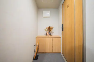 a hallway with a wooden door and a plant on a cabinet at MARUMI HOTEL Uguisudani\u9daf\u8c37 in Tokyo