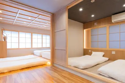 a japanese bedroom with two beds and a large mirror at MARUMI HOTEL Uguisudani\u9daf\u8c37 in Tokyo