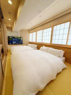 a bedroom with four large white beds and windows at Rakuyu asakusa in Tokyo