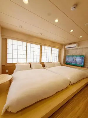 a large white bed in a room with windows at Rakuyu asakusa in Tokyo