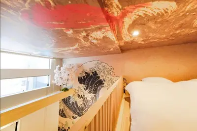 a bedroom with a bed and a painting on the wall at Hokusai Great Wave x Modern Japan in Tokyo