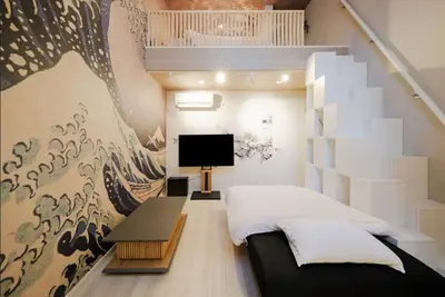a bedroom with a bed and a wall with a mural at Hokusai Great Wave x Modern Japan in Tokyo