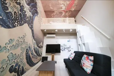 a living room with a couch and a large mural at Hokusai Great Wave x Modern Japan in Tokyo