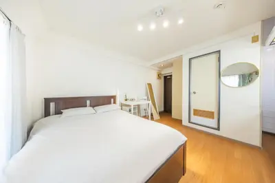 a bedroom with a large white bed and a table at 603 8 min walk to Ikebukuro 6 min walk to Kanamecho Station25m Max 2 people Direct access to Tokyo, Shinjuku, Shibuya, Ueno in Tokyo
