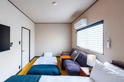 a bedroom with two beds and a couch at \u3077\u3075\u304b\u6620\u6708\u6771\u5411\u5cf6 Pufuka Eigetsu Higashi Mukoujim in Tokyo