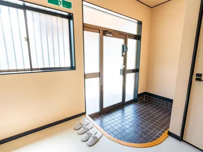 an empty room with shoes in front of a door at \u3077\u3075\u304b\u6620\u6708\u6771\u5411\u5cf6 Pufuka Eigetsu Higashi Mukoujim in Tokyo