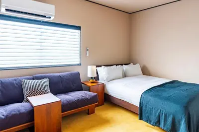 a small bedroom with a bed and a couch at \u3077\u3075\u304b\u6620\u6708\u6771\u5411\u5cf6 Pufuka Eigetsu Higashi Mukoujim in Tokyo