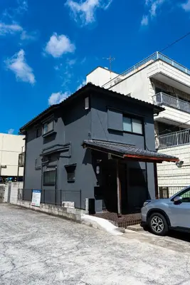 a black house with a car parked in front of it at \u3077\u3075\u304b\u6620\u6708\u6771\u5411\u5cf6 Pufuka Eigetsu Higashi Mukoujim in Tokyo