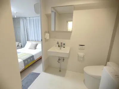 a bathroom with a sink and a toilet and a bed at 302Room,7-minute walk from Uguisudani Station located on the 3nd floor of an apartment-style building Twin room No elevator in Tokyo