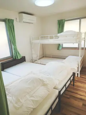 two bunk beds in a room with green curtains at Uenton Hotel in Higashi-Mukojima 2F in Tokyo