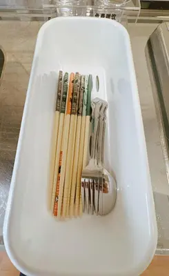 a white plate with forks and chopsticks and a spoon at F House Shinjuku in Tokyo