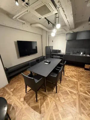 a conference room with a table and chairs and a flat screen tv at Villa Customa \u30f4\u30a3\u30e9\u30ab\u30b9\u30bf\u30de in Tokyo