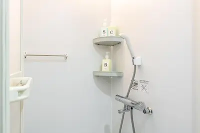 a white bathroom with a shower and a sink at \u6771\u65b0\u5bbf1007 Good location within 15 minutes of Shinjuku Station in Tokyo