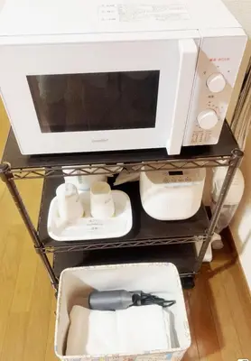a microwave sitting on a shelf with a bow tie at 101 B&B in Tokyo Kita Ward Convenient Location Near 4 Stations 3 km to Ikebukuro Chinatown in Tokyo