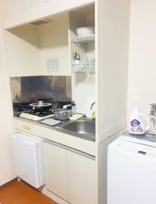 a white kitchen with a stove and a sink at Tokyo Kita-ku B&B, 201, four stations with convenient transportation, 3 km from Chinatown Ikebukuro in Tokyo