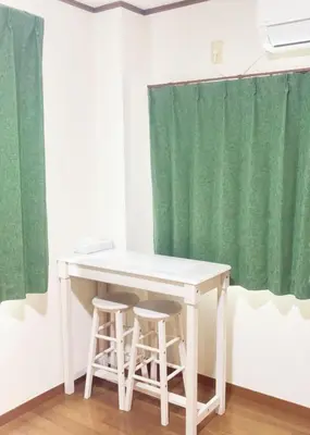 a white table and two stools in front of a green curtain at Tokyo Kita-ku B&B, 202, convenient transportation to four stations, 3 km from Chinatown Ikebukuro in Tokyo