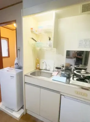 a small kitchen with a sink and a refrigerator at Tokyo Kita-ku B&B, 202, convenient transportation to four stations, 3 km from Chinatown Ikebukuro in Tokyo