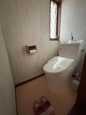 a bathroom with a toilet and a window and a pair of slippers at \u53cc\u693fCamellia House in Tokyo
