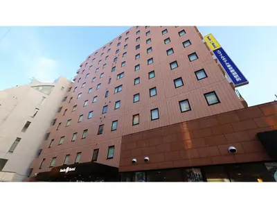 a tall brown building with a sign on it at Smile Hotel Tokyo Ayase Ekimae - Vacation STAY 14730v in Tokyo