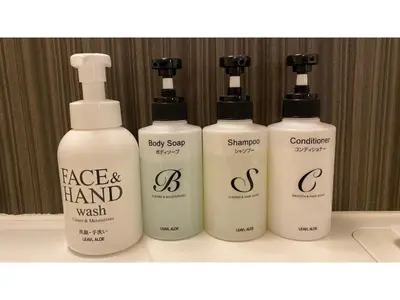 three bottles of face and hand wash on a shelf at Smile Hotel Tokyo Ayase Ekimae - Vacation STAY 14722v in Tokyo