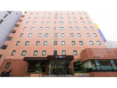 a tall red building with a store in front of it at Smile Hotel Tokyo Ayase Ekimae - Vacation STAY 14755v in Tokyo